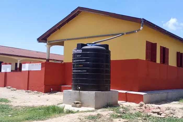 A renovated school block with a rainwater tank alongside