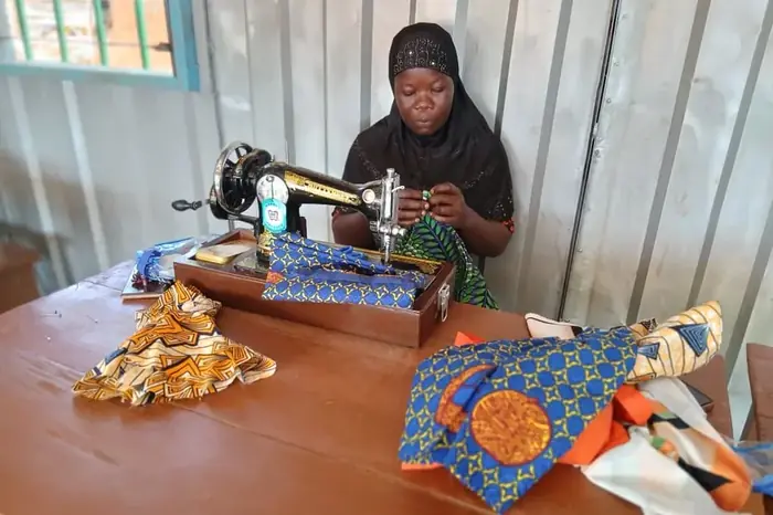 A dressmaker at her sewing machine with printed fabric