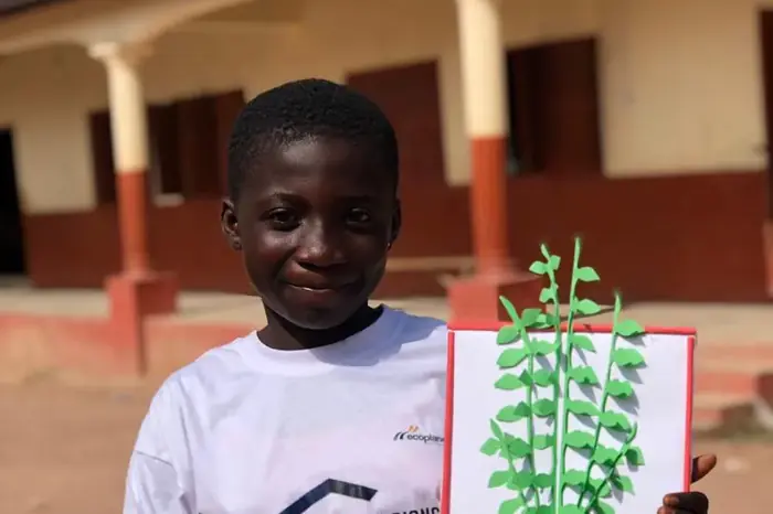 A pupil holding up a drawing made in the school environmental club