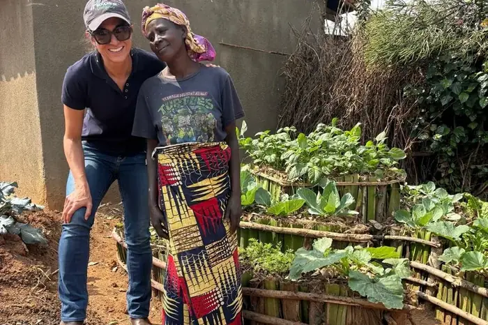 An EcoPlanet team member with a household gardener beside her vegetable beds