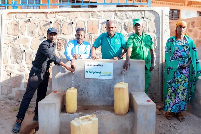 Community members filling containers at a piped water point