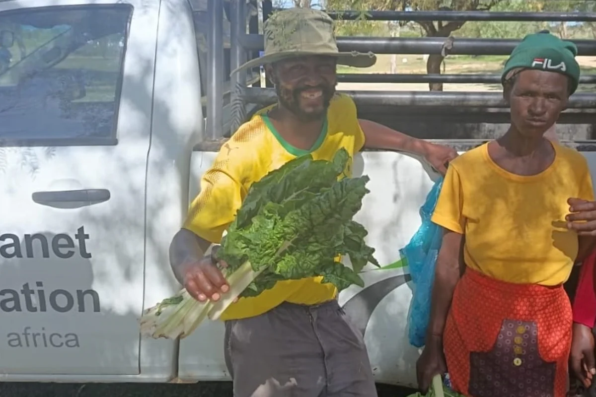 Workers holding harvested greens from the farm garden near Makhanda
